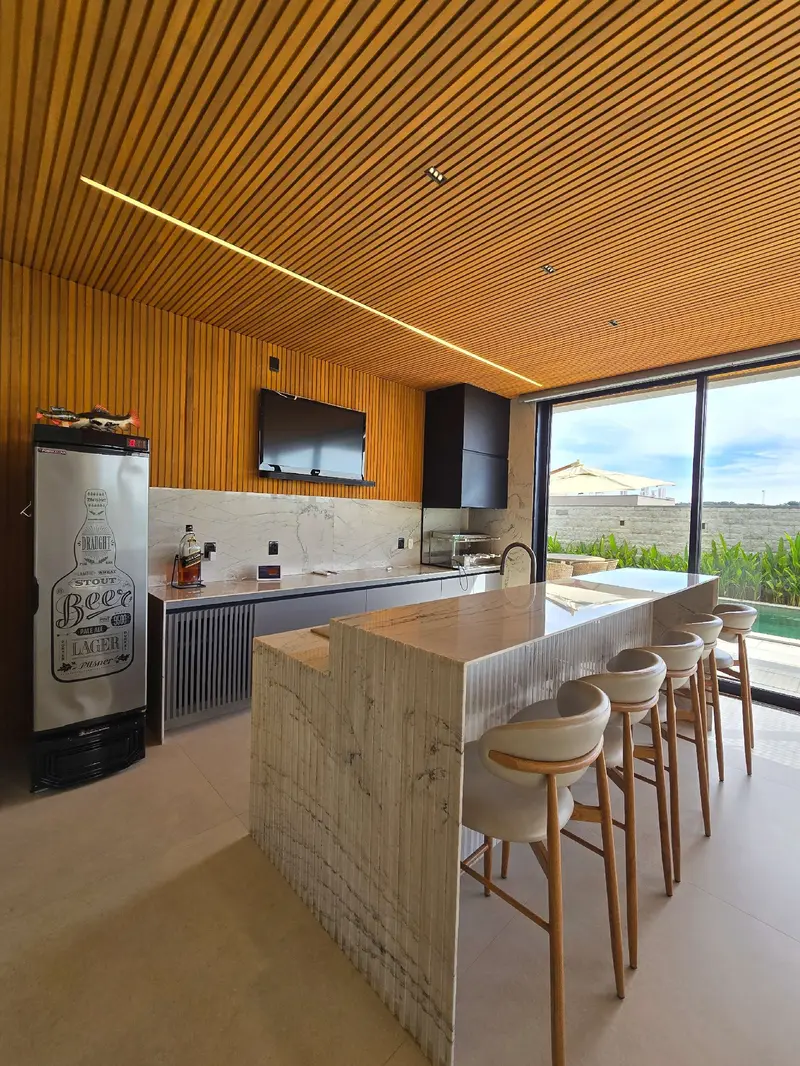 Espaço gourmet com ilha e parrilha argentina do sobrado no Jardins Itália, Goiânia